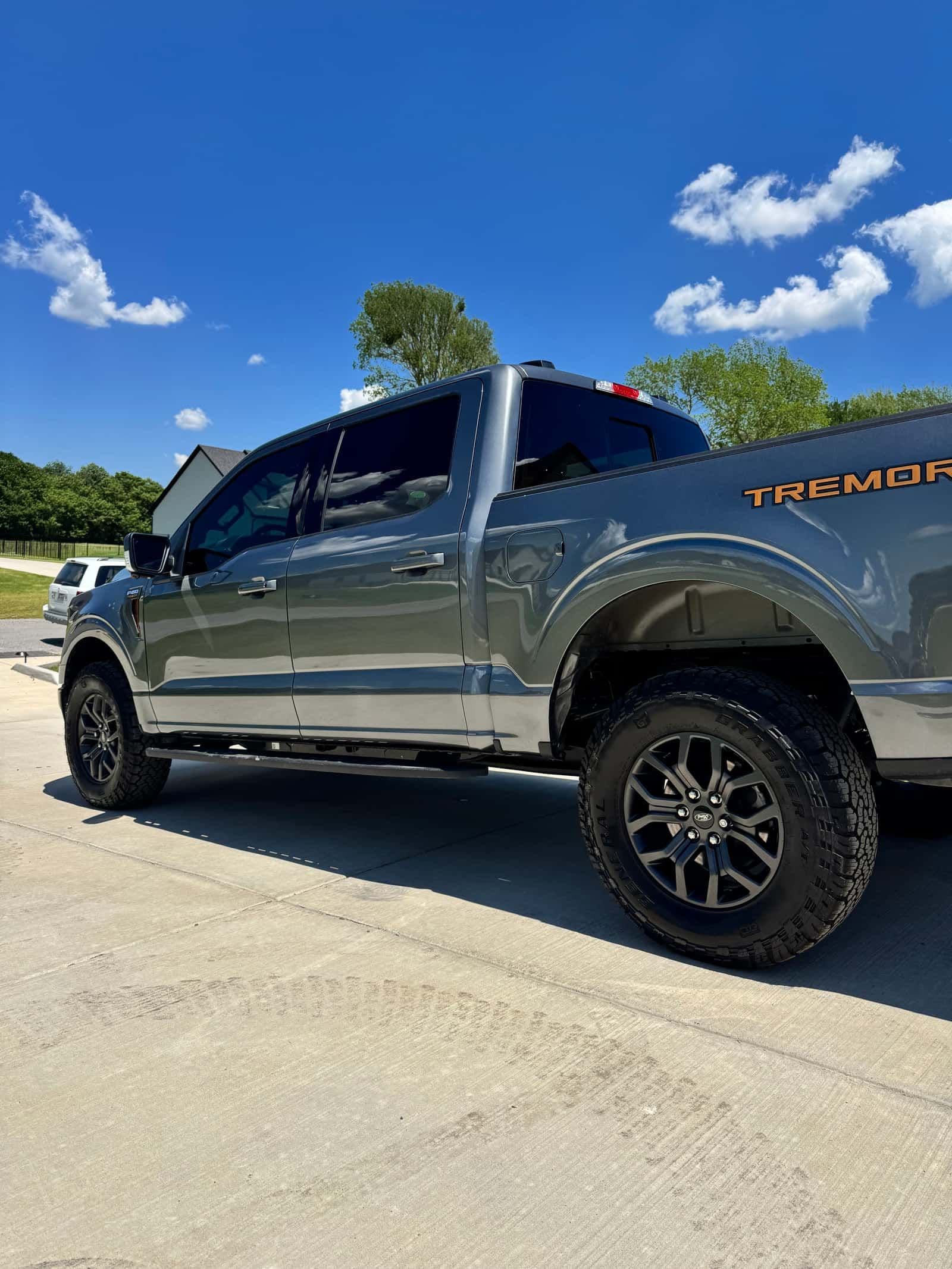 A detailed gray Ford F-150 Tremor, side profile in a driveway
